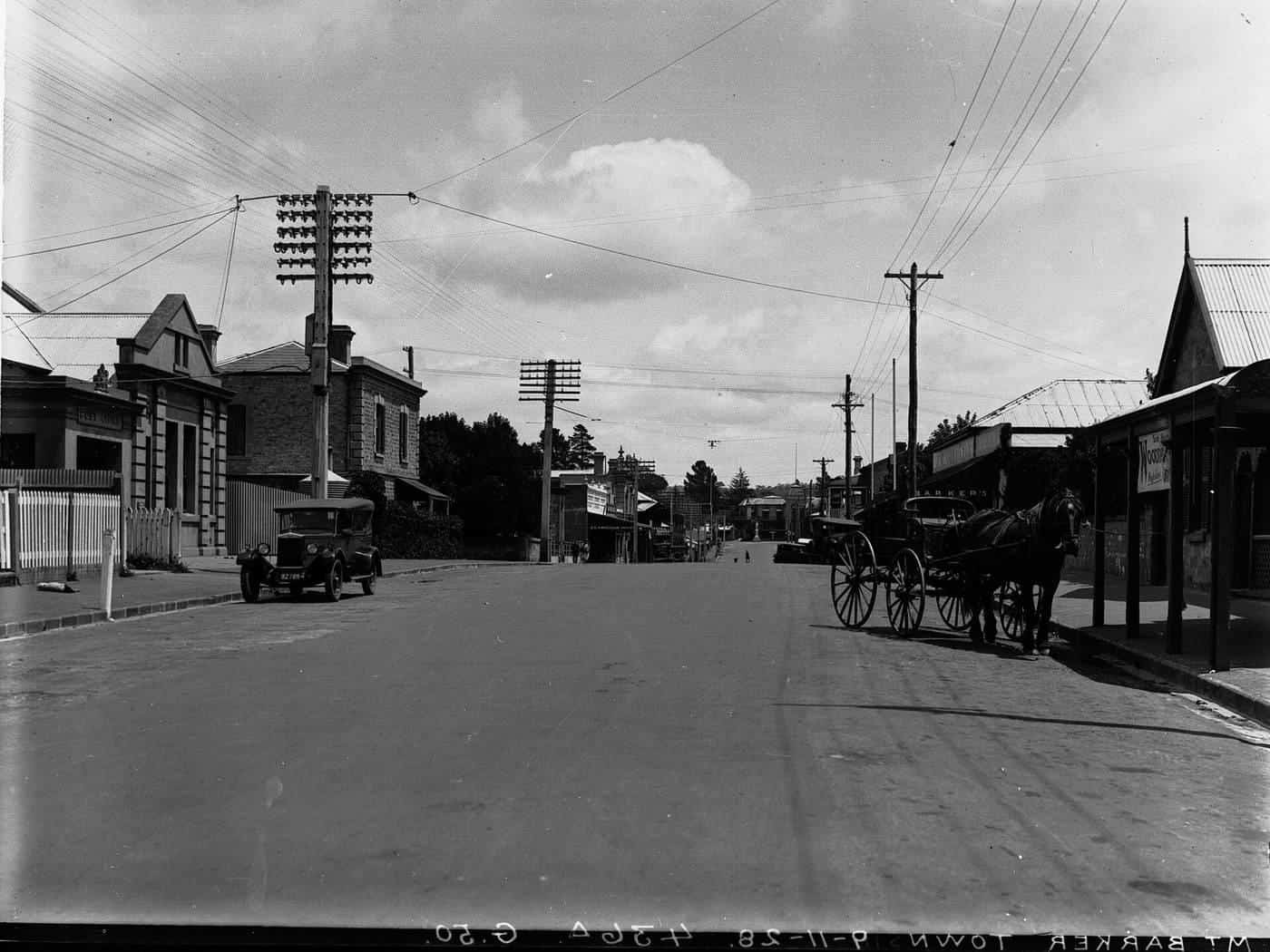Historic photo of a country town main street lined with shops and verandahs