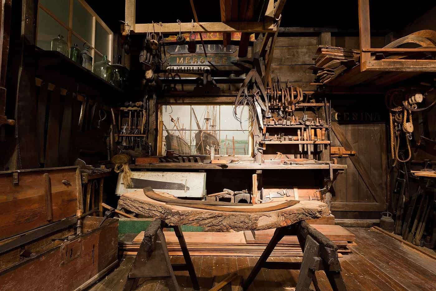 Old timber workshop with workbenches and tools under a high roof