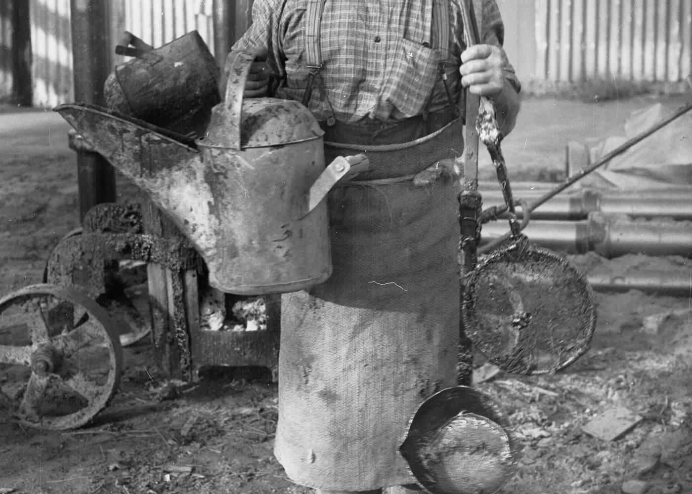 Historic photo of a plumber at work with tools and a watering can