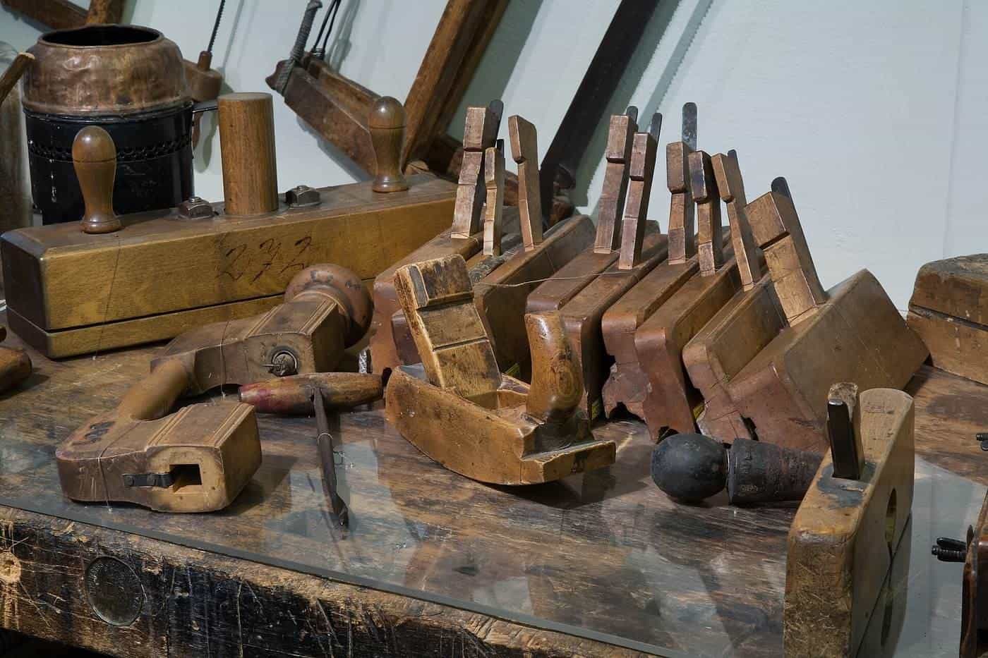 Old woodworking planes and hand tools on a workshop bench