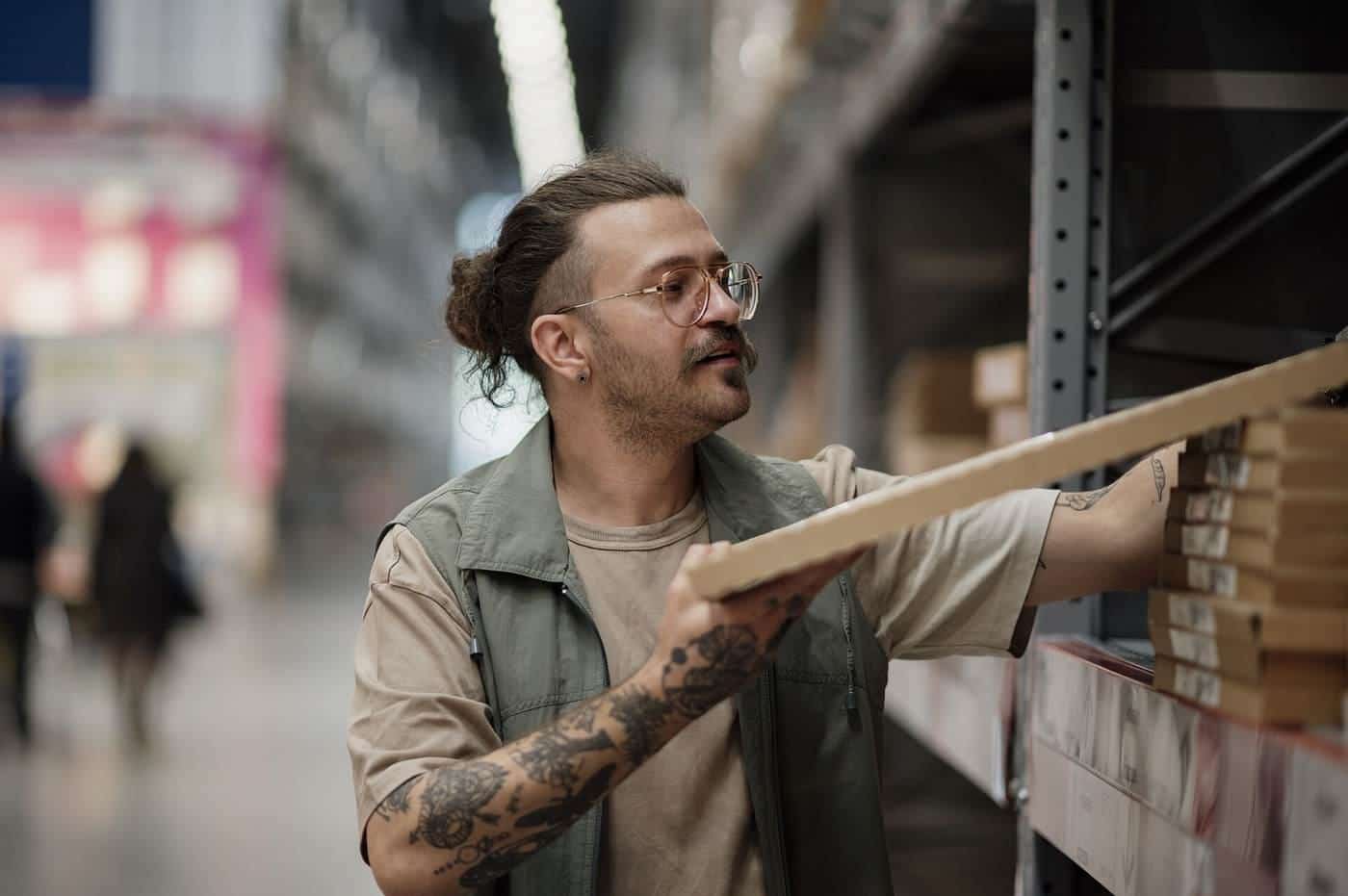 Man selecting wooden planks from shelves in a hardware store